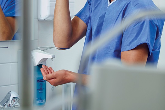 A nurse disinfects his hands in the hospital.