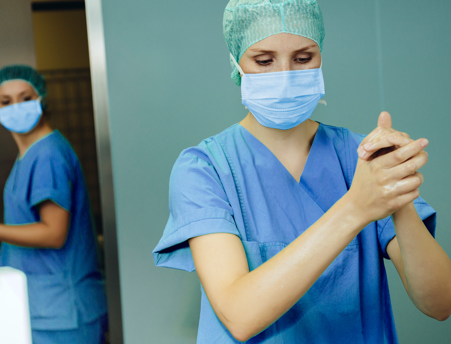 A surgeon disinfects her hands before an operation.