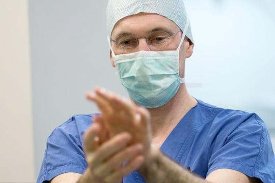A surgeon disinfects his hands before an operation.