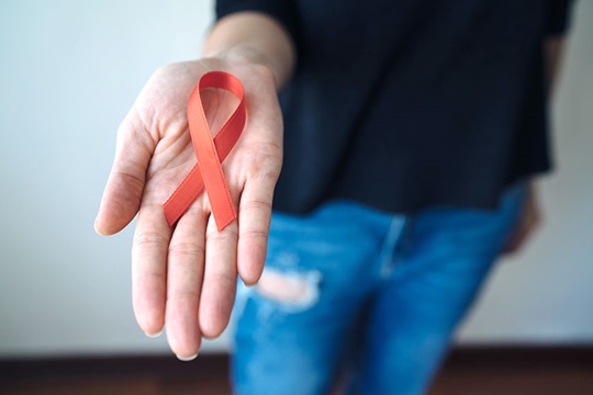 The red ribbon - a symbol of awareness and support for people living with HIV.